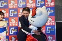 サンリオの取締役である下村陽一郎（左）とハグするハローキティ（右）。