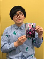 「ゼロから始める事故物件生活」1巻を手にする松原タニシ。