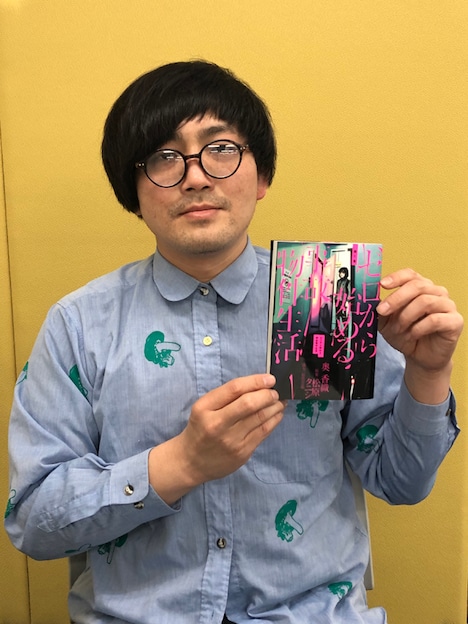 「ゼロから始める事故物件生活」1巻を手にする松原タニシ。