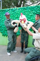 白ヘビに巻き付かれる板垣巴留。（撮影：石川真魚）