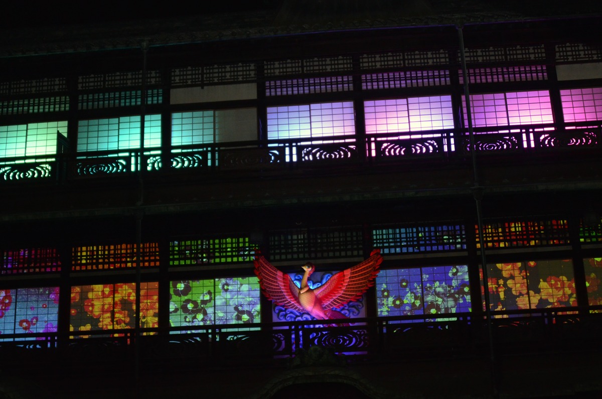 プロジェクションマッピング「道後温泉×ネイキッド MESSAGE-火の鳥、到来-」より、椿の花が描かれた場面。