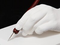 板垣巴留の手をかたどった石膏製モニュメントと、愛用ペン。