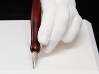 板垣巴留の手をかたどった石膏製モニュメントと、愛用ペン。