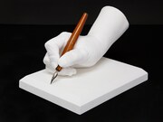 車田正美の手をかたどった石膏製モニュメントと、愛用ペン。