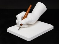 車田正美の手をかたどった石膏製モニュメントと、愛用ペン。