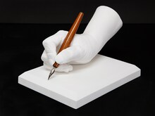 車田正美の手をかたどった石膏製モニュメントと、愛用ペン。