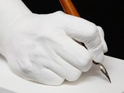 車田正美の手をかたどった石膏製モニュメントと、愛用ペン。