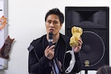 持参した「ホワッツマイケル」グッズを見せる栄喜。