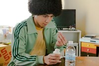 ドラマ「WOWOWオリジナルドラマ アフロ田中」より、デトックスのためにサプリを飲もうと意気込む田中。