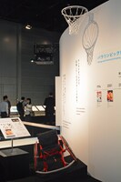 第6章「パラリンピック競技を描くマンガ・アニメ」のコーナーより、車イスバスケットボールのゴールと競技用車イス。