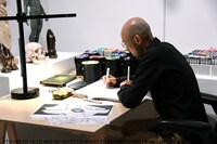 会場で作画作業をする小畑健。