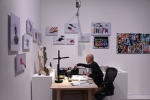 会場で作画作業をする小畑健。