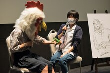 左から、ゲストビーストのイグアナと触れ合う板垣巴留と西修。