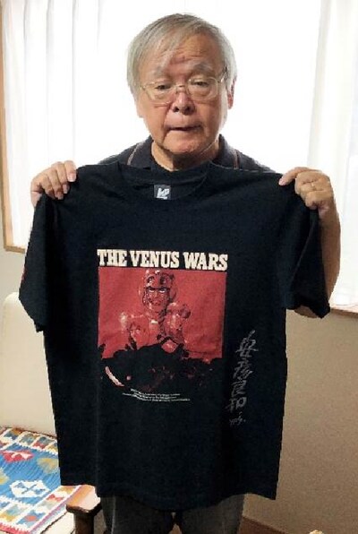 サイン入りTシャツを持った安彦良和。