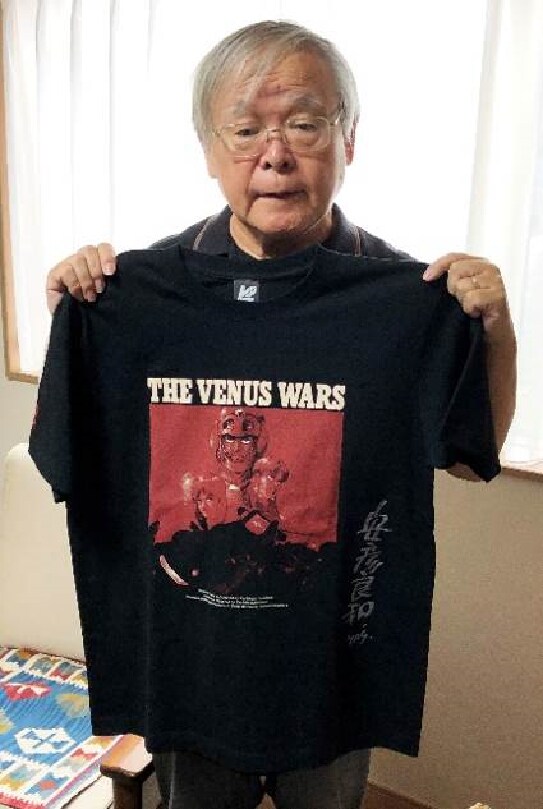 サイン入りTシャツを持った安彦良和。