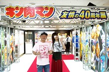 「キン肉マン 友情の40周年展」入場ゲート前に立つ、嶋田隆司（ゆでたまご）と上坂すみれ。