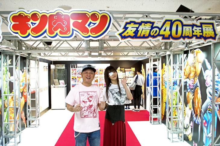 「キン肉マン 友情の40周年展」入場ゲート前に立つ、嶋田隆司(ゆでたまご)と上坂すみれ。