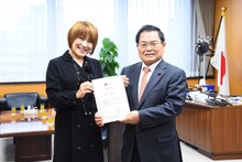 任命式の様子。左から松本梨香、竹本直一大臣。