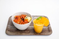 「らんまん食堂」ルフィのお肉もりもりから揚げ「ドン!!」ぶり（左）、ナミのサニー号で採れたオレンジたっぷりジュース（右）。