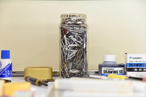 ペン先が溢れんばかりに入った瓶。