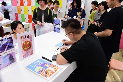 レシピカード1枚1枚に直筆でサインを入れていくコヤマシゲト。