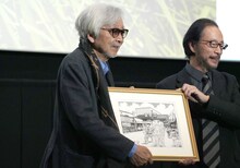 秋本治（右）からイラストを手渡される山田洋次監督（左）。