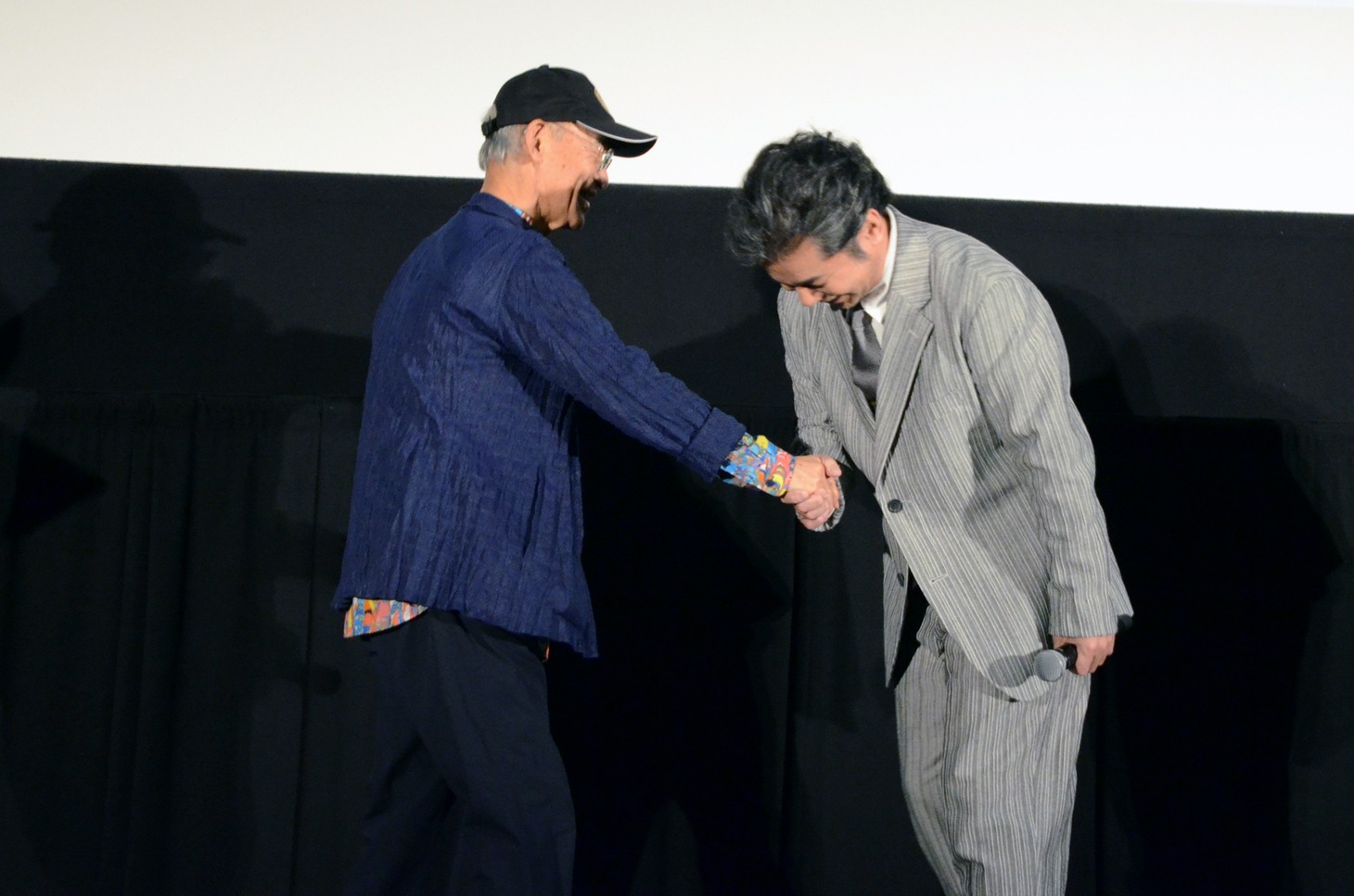 握手をする富野由悠季（左）と中村正人（右）。