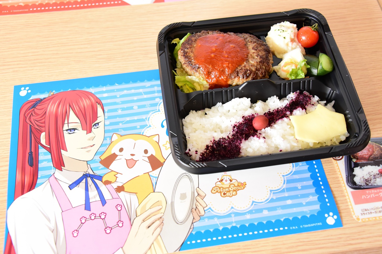 「ハンバーグ弁当 with ラスカルチーズ」には、特製の包み紙・箸袋も付属する。