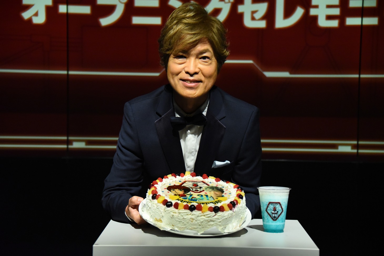 特注のケーキを持つ古谷徹。