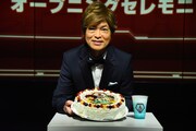特注のケーキを持つ古谷徹。