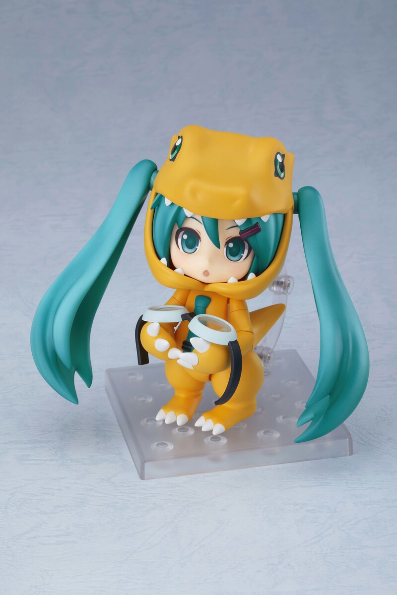 「キョトン顔」を付けた「ねんどろいど 初音ミク きぐるみアグモンVer.」とオプションパーツ「ゴーグル」。