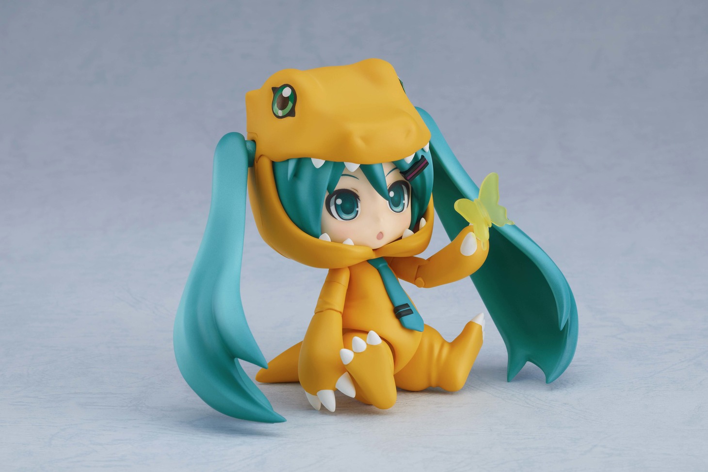 「キョトン顔」を付けた「ねんどろいど 初音ミク きぐるみアグモンVer.」とオプションパーツ「ちょうちょ」。