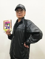 「2万光年翔んで新潟」を手にする魔夜峰央。