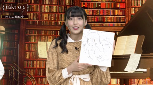 LAMが描き下ろしたきらきら星の色紙を持つ指出毬亜。