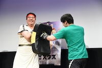 笑顔でパンチを受ける村上。