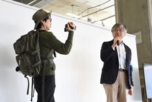 神村靖宏社長（右）をカメラに収める岩永哲哉（左）。