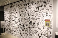 サブキャラクターのイラストが壁一面に敷き詰められたコーナー。