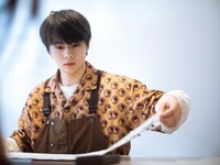 机に墨汁をこぼしながらも、書き進める鶴房汐恩。