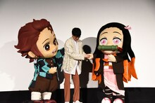 竈門禰豆子の着ぐるみ（右）をアテンドする花江夏樹（中央）。