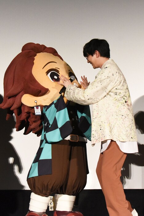 竈門炭治郎（左）とハイタッチする花江夏樹（右）。