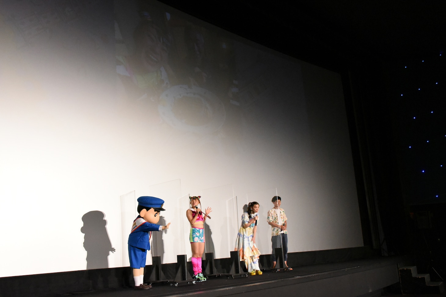 フワちゃんの写真を見る一同。写真は最近になって担任教師と再会したときのもの。