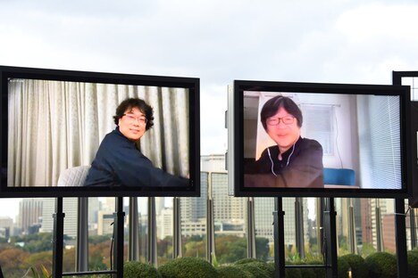 オンライン上で握手するようなポーズをとるポン・ジュノ（左）と細田守（右）。