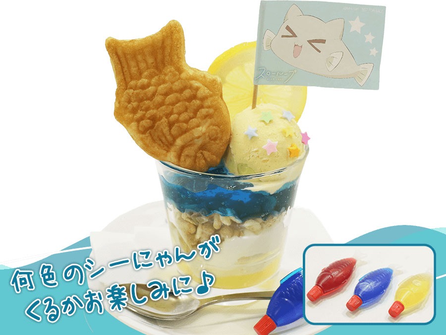 レモンスライスの太陽が眩しく照らす海で、楽しそうに泳ぐシーにゃんをイメージした「シーにゃんのカラフルお魚SEAパフェ」。シーにゃんに見立てた魚のタレビンには「ブルーキュラソー」「ストロベリー」「パッションフルーツシロップ」がランダムで入っている。何色が来るかは来てのお楽しみ。