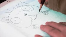 ドキュメンタリー映画「Hand-Drawn」より、「電脳コイル」に登場するデンスケを描く磯光雄。