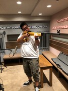 モデルガンで遊んでいる大寺さん……ではなく、ある作品に登場した珍しいエアライフルの各部の動作音を、効果音として録音しているところ。