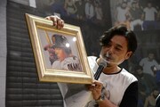 板垣恵介が描いた岡本和真選手の似顔絵を掲げるアルコ＆ピース平子。