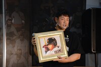 板垣描き下ろしの似顔絵を持つ岡本選手。