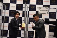 講談社電子書籍営業担当の河原井勇樹氏がトロフィーを受け取る様子。