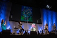 キービジュアルを見る登壇者たち。