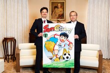 ベトナムで刊行予定の馬場民雄「SON GOAL!（ソン ゴール！）」1巻のパネルを手に、ヴー・ホン・ナム大使（右）と青柳昌行CPO（左）による記念撮影。（撮影：野口彈）